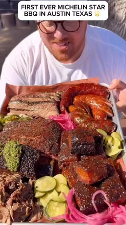 Plateau de barbecue comprenant brisket, pulled pork, et diverses viandes accompagnées de légumes marinés.