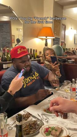 Customers eating barbecue dishes and using phones inside MELT DELI Les halles with bottles and a lamp in the background