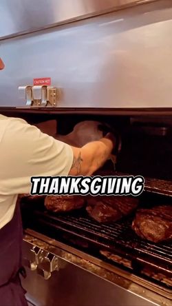 Un chef place des morceaux de brisket dans un four professionnel au restaurant MELT BATIGNOLLES, barbecue texan à Paris.