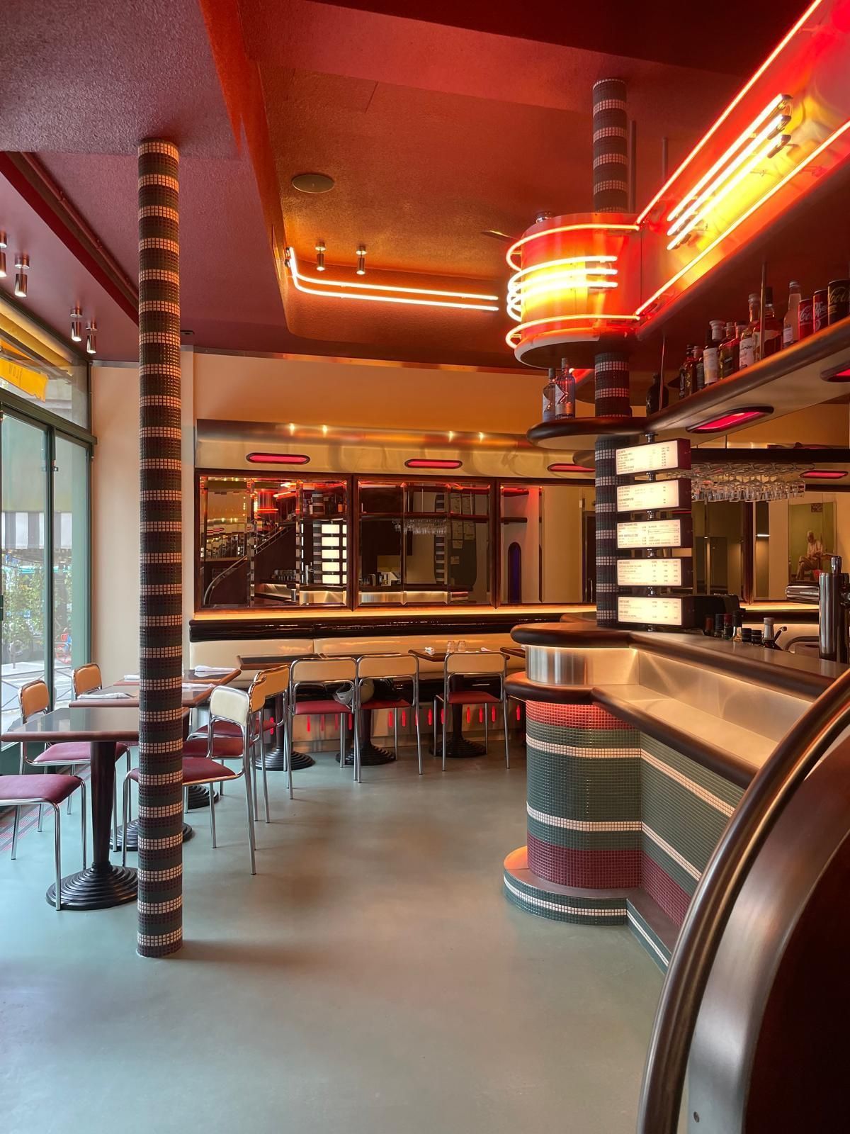 Intérieur du restaurant MELT Pantheon avec bar et chaises, ambiance rétro et éclairage néon rouge