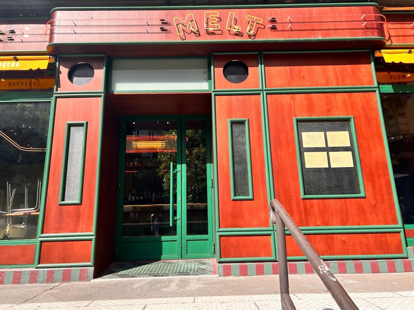 Façade en bois rouge avec cadre vert du restaurant MELT Pantheon à Paris, spécialisé en viande barbecue texan.