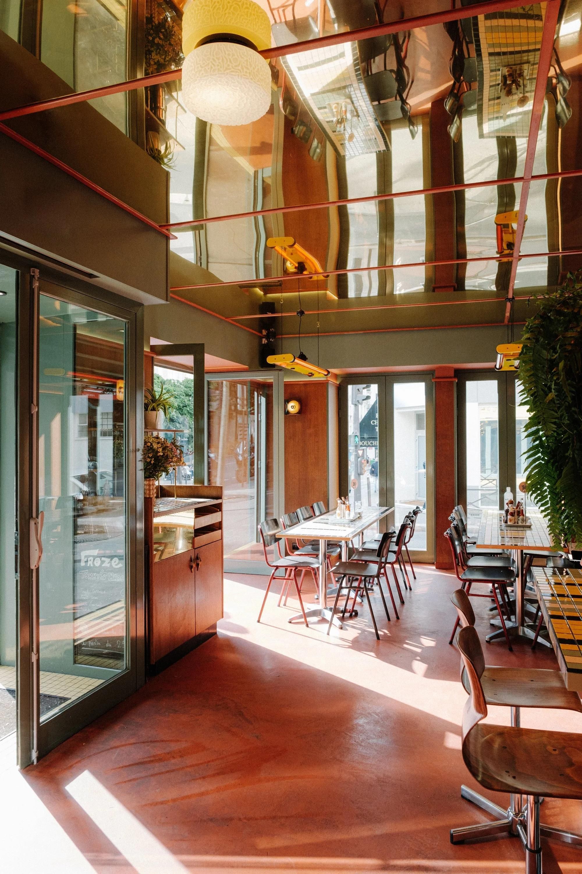 Salle intérieure lumineuse du restaurant MELT Cambronne avec tables, chaises et grande baie vitrée.
