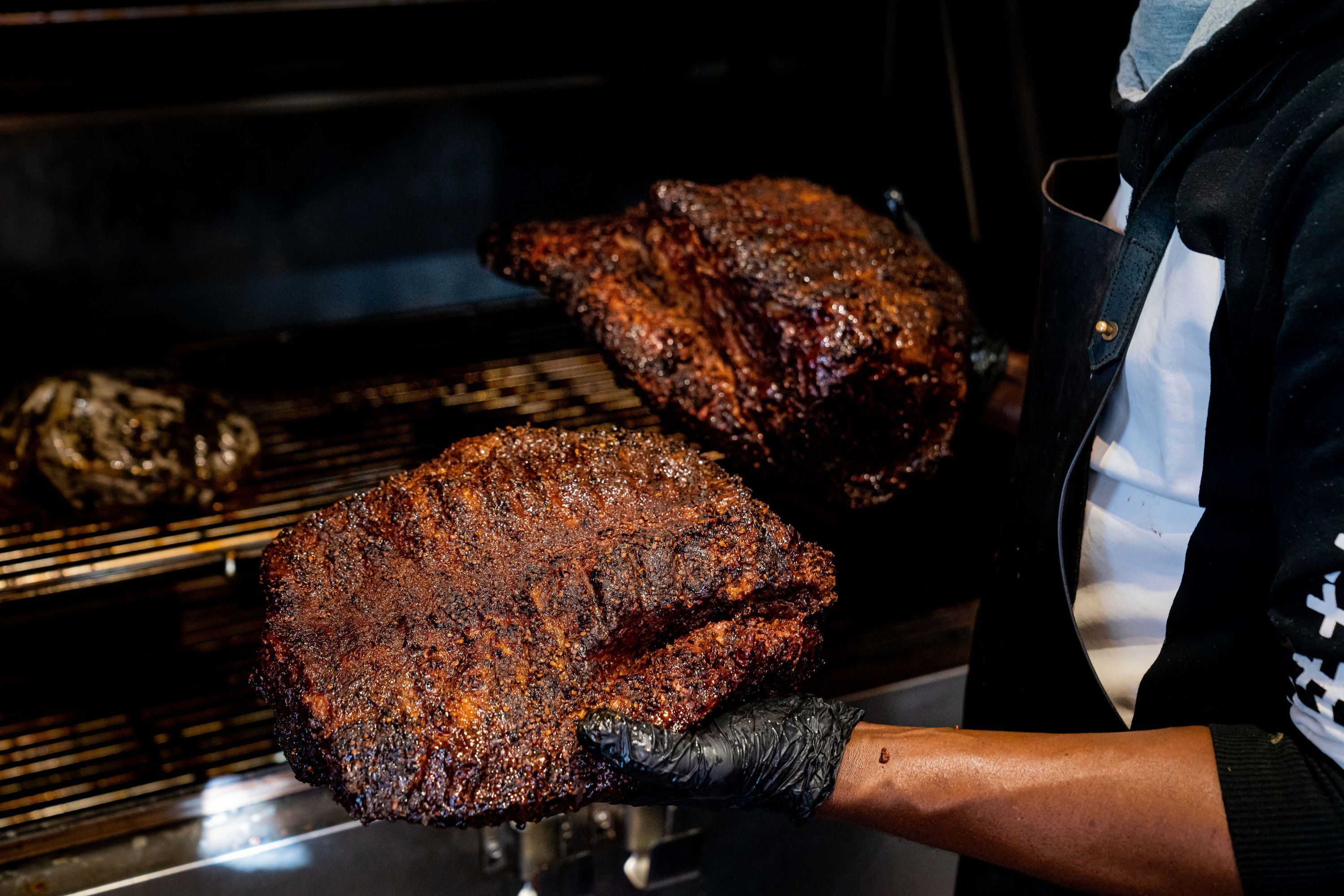 Brisket fumé, essentiel du barbecue texan, dans une cuisine de restaurant à Paris.