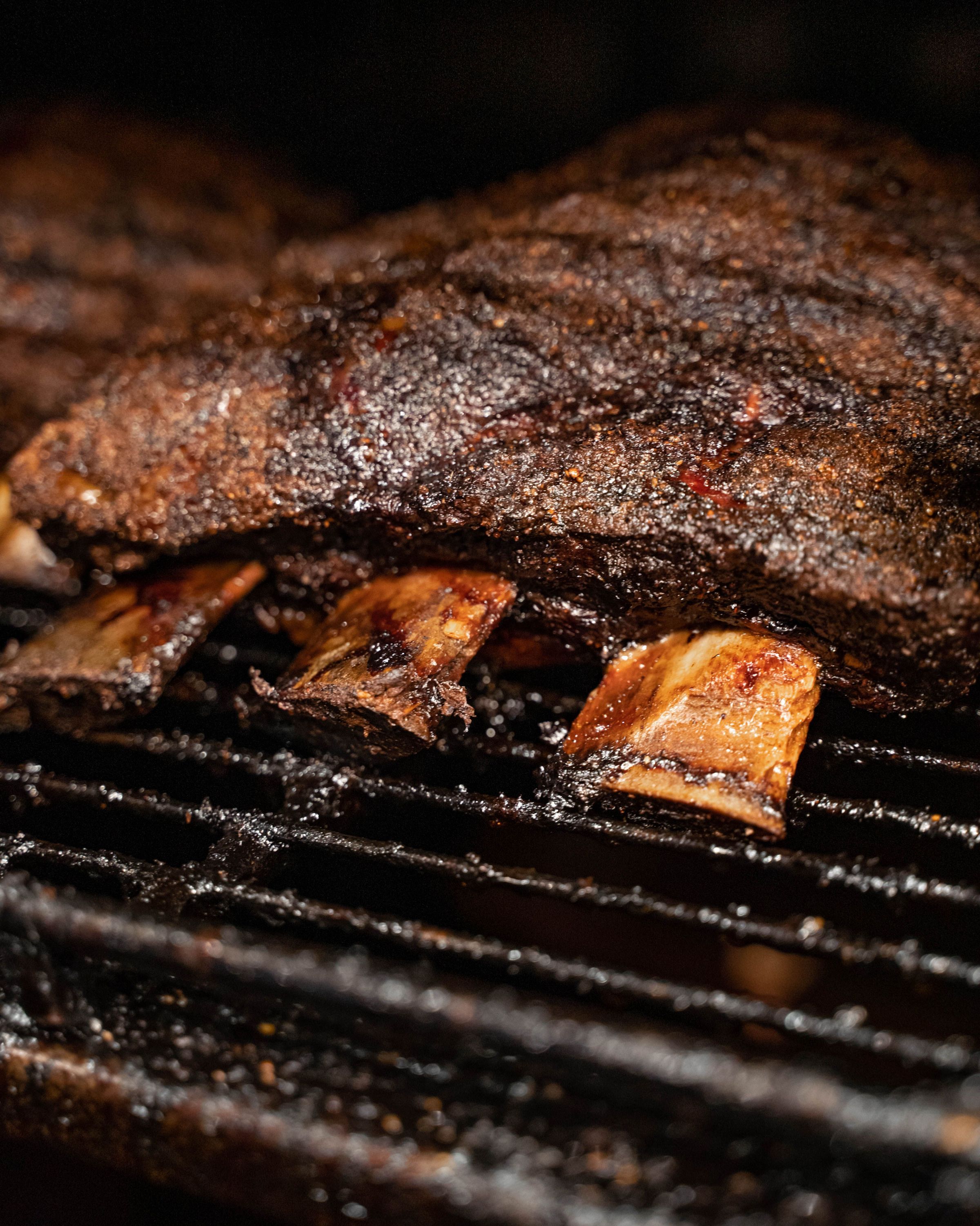 A chef holds a large slab of barbecue brisket, showcasing its smoky glaze and enticing texture.