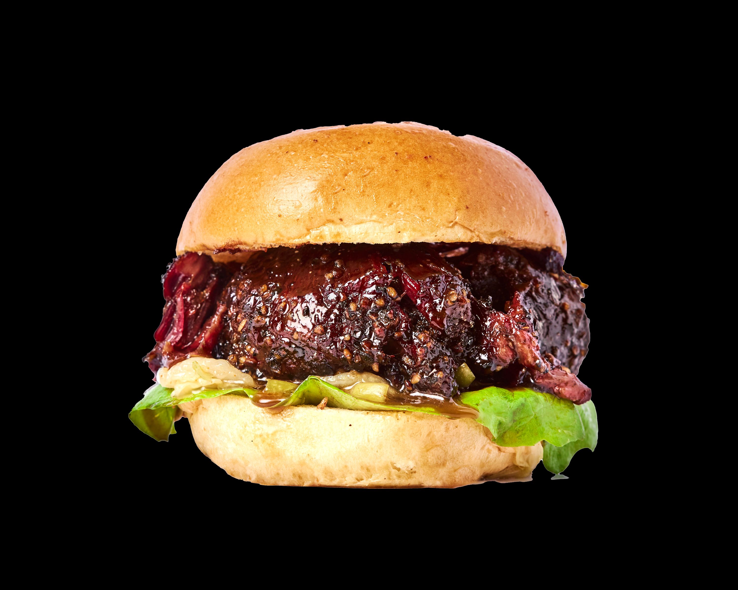 A delicious burger featuring tender brisket, barbecue sauce, and lettuce on a soft bun.