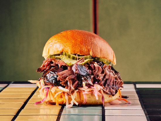 Burger garni de brisket, coleslaw et cornichons, en style barbecue texan.