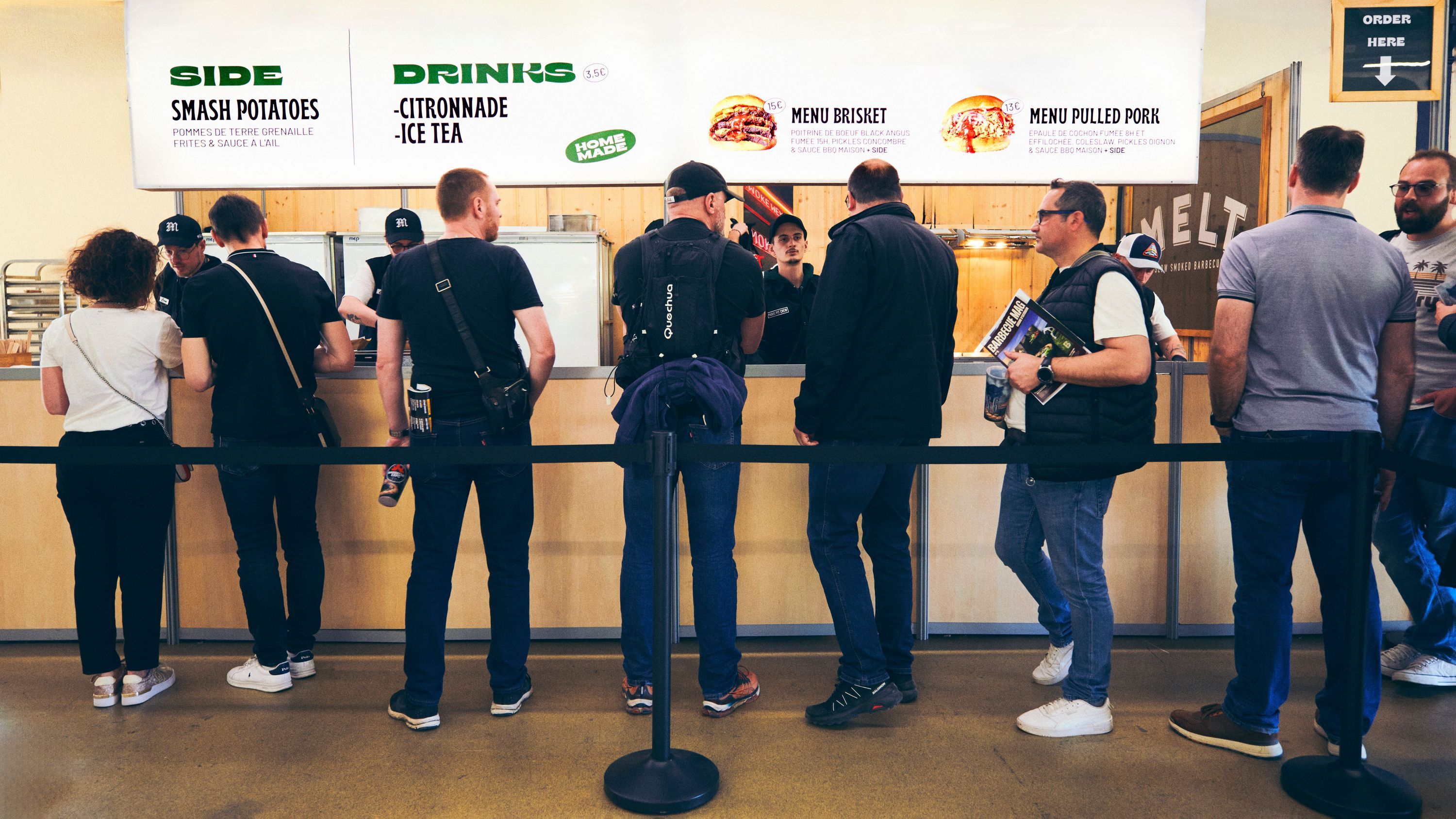 Customers line up to order menu items like brisket and pulled pork at MELT, a deli in Paris.