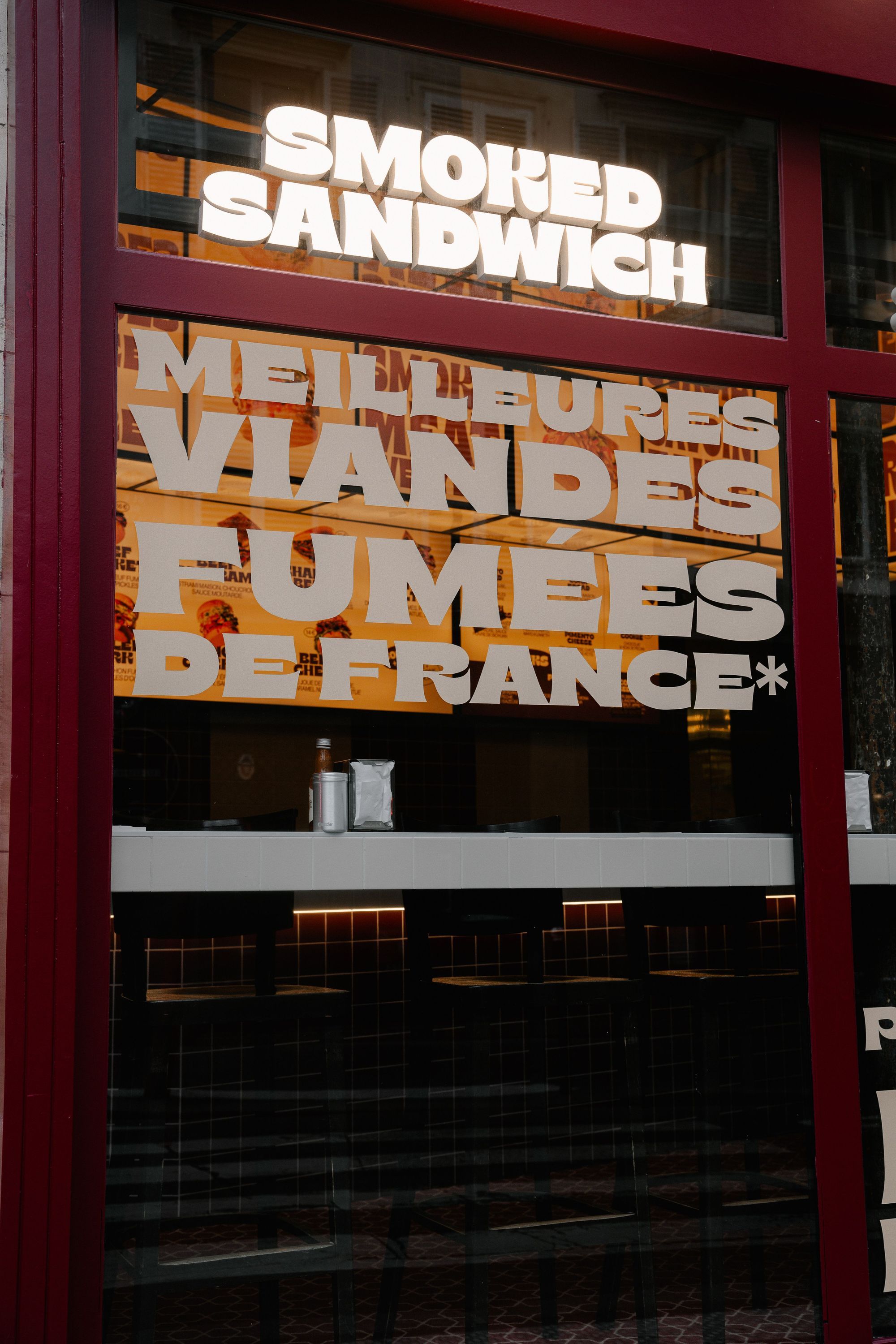 Vitrine du MELT DELI avec inscription sur les viandes fumées et les meilleurs sandwiches.